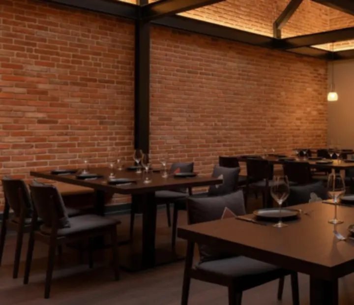 Loft stílusú étterem belső tere, meleg fényekkel és elegáns asztalokkal